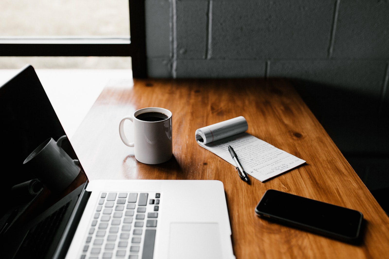 Blog d'entreprise - MacBook Pro, tasse en céramique blanche et smartphone noir sur table